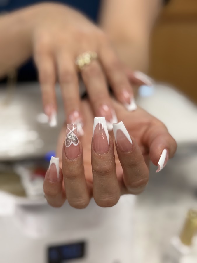 Elegant white French-tip nails with a delicate silver glitter heart, finished at Sky Nails & Spa